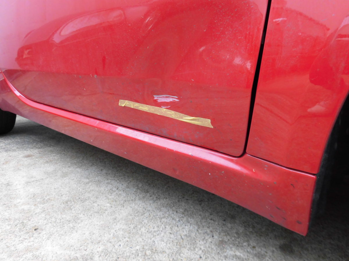 赤色のフィアット500の助手席側のドアです。下の方にキズ、凹みがあります。