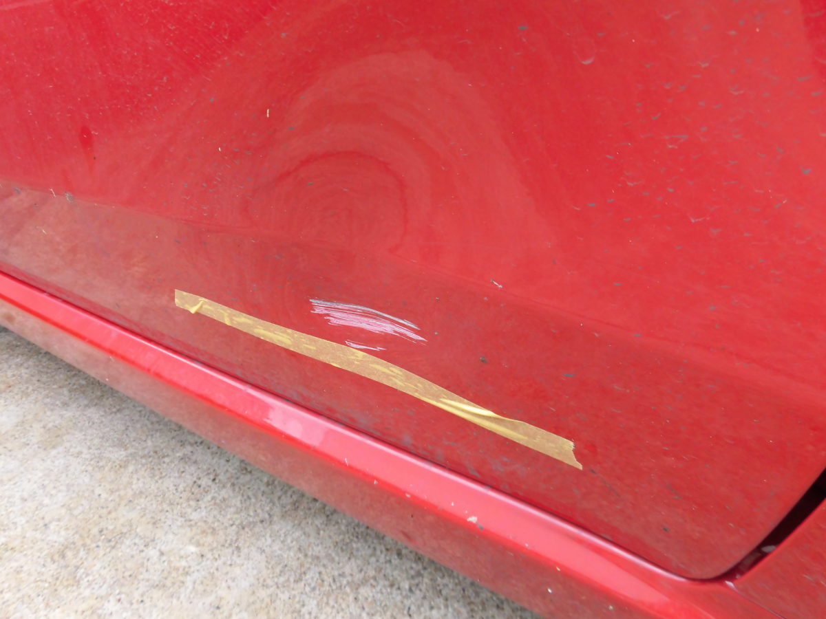 赤色のフィアット500ドアの下の方のキズの写真を拡大したものです。